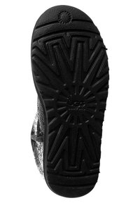 Suela exterior de goma negra con un patrón en zigzag texturizado. Presenta un diseño circular central y la marca "UGG" en relieve.