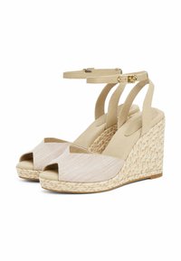 Sandali con zeppa beige dal design open toe, parte superiore in tessuto con finitura testurizzata e tacco in stile juta intrecciata. Fascetta alla caviglia con fibbia.