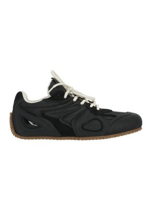 Sneaker basso nero con lacci bianchi, dettagli di design ritagliati e suola marrone texturizzata.