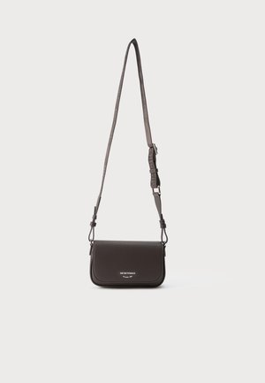 Sac bandoulière en cuir noir avec sangle réglable et texte du logo argenté au centre avant sur fond clair uni.
