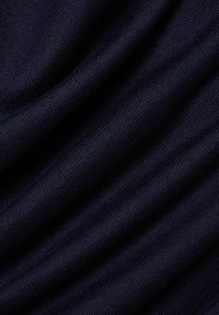 Donkerblauwe gebreide stof met een zachte textuur, gekenmerkt door een gladde, gelijkmatige weving en subtiele variaties in tint over het oppervlak.