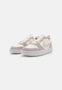 Baskets roses et blanches avec une tige en cuir lisse, une pointe perforée pour la respirabilité, des semelles blanches, et un détail de logo subtil.
