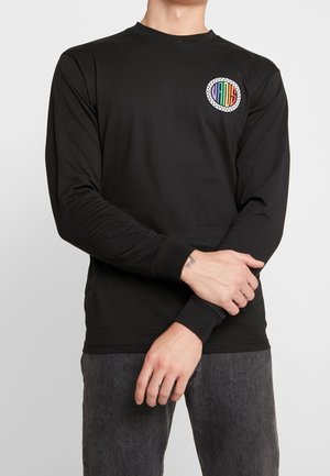 Czarna koszula z długim rękawem uszyta z miękkiego materiału, z okrągłym, wielobarwnym logo na piersi z białą, kropeczkowaną obwódką i prążkowanymi mankietami.