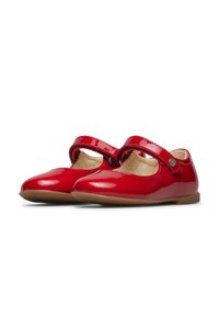 Chaussures Mary Jane rouges brillantes pour enfants avec des sangles Velcro et des semelles intérieures rembourrées beiges sur fond blanc.