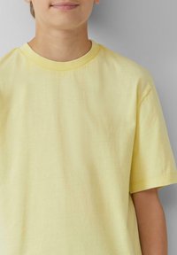 Geel katoenen t-shirt met een ronde halslijn en korte mouwen, voorzien van een soepele textuur en een minimalistisch ontwerp.