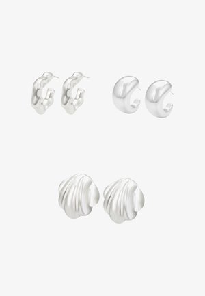Tre par sølvøreringe: abstrakt hoop, glat buet design og tekstureret skalsform. Alle har en poleret metallisk finish.
