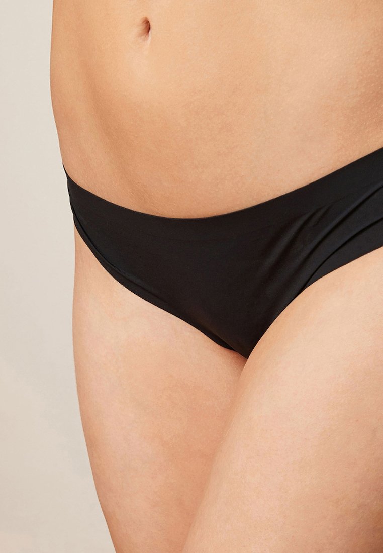Czarny dół bikini o gładkiej teksturze, niskim kroju i minimalnych detalach szwów, odpowiedni do noszenia na basenie lub jako bielizna.
