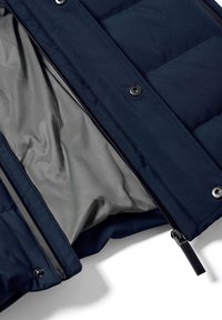 Marinblå puffjacka med en slät grå foder, utrustad med dragkedja, tryckknappar och quiltad struktur på ytterlagret.