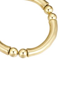 Náhrdelník zlatého tónu s zakriveným, segmentovaným dizajnom a hladkými, lesklými povrchmi a guľovými akcentmi.