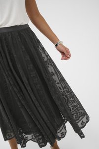 Fustă din dantelă neagră cu un model floral, având un design stratificat și un brâu neted. Accentuata cu o margine ondulată și o textură transparentă.