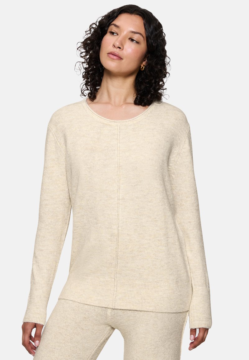 Maglione color crema, morbido al tatto, con scollo rotondo, maniche lunghe e dettagli delle cuciture sottili sulla parte anteriore.