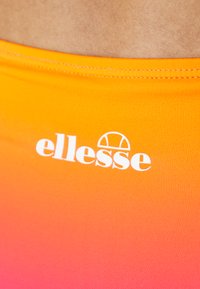 Oranžová gradientová tkanina s hladkou textúrou, na ktorej sa v strede blízko vrchu nachádza biele logo "ellesse".
