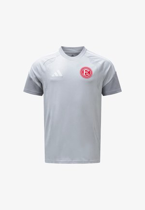 Jasnoszary sportowy trykot z krótkimi rękawami, logo Adidas na prawym piersi oraz czerwono-biała odznaka klubu Fortuna Düsseldorf na lewym piersi.