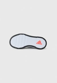 Semelle de chaussure noire avec une surface texturée blanche. Présente un motif hexagonal et un logo Adidas orange. Design non marquant.