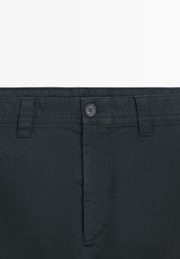 Dark blue cotton trousers featuring a button closure, front pockets, and a smooth texture with a clean, tailored design.