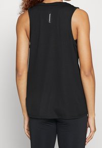 Débardeur noir sans manches avec un col rond, tissu côtelé et un accent blanc vertical à l'arrière. Texture douce et coupe décontractée.