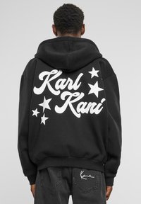 Black hoodie with white “Karl Kani” text and star graphics on the back. Features a large hood and ribbed cuffs and hem.