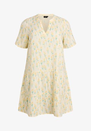 Kermanvärinen lyhythihainen mekko, jossa kerroksittainen hame ja keltainen kukkakuosi, V-pääntiellä.