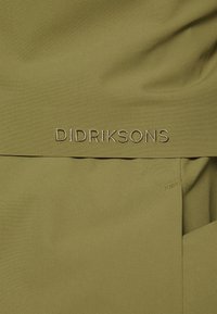 Zielony materiał o gładkiej fakturze, z haftowaną nazwą marki "DIDRIKSONS" w pasującym zielonym niteczce. Prosty i czysty design.