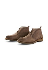 Stivaletti in suede marrone alla caviglia con un design con lacci, punta tondeggiante e una piccola linguetta sul retro. Presentano una suola testurizzata e un rifinitura in marrone a contrasto.