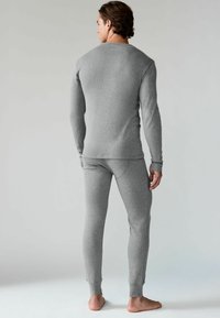 Grau langärmliges Thermo-Oberteil und passende enganliegende Unterteile aus strukturiertem Stoff. Enganliegende Silhouette mit gerippten Details und nahtlosem Design.