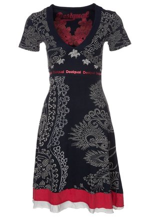 Zwarte jurk met korte mouwen met witte bloemen- en paisleypatronen, rode band onder de buste met tekst "Desigual" en rode en witte zoomlagen.