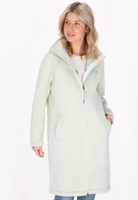 Giacca lunga di un verde chiaro con tessuto testurizzato, colletto alto, zip frontale e tasche laterali. Presenta una vestibilità rilassata e un rivestimento interno morbido.