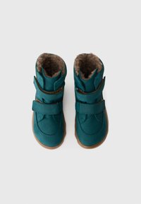 Un paio di stivali invernali per bambini di colore teal con rivestimento interno marrone e due cinturini regolabili, visti dall'alto su uno sfondo bianco.