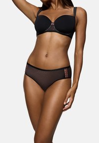 Schwarzer BH mit glatten Cups und Spitzenakzenten. Passender schwarzer Bikini mit durchsichtigen Mesh-Einsätzen und Spitzenverzierungen an den Seiten.