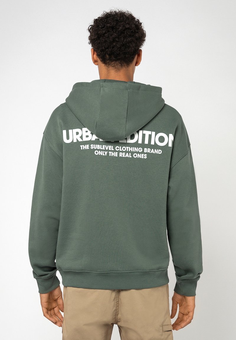 Grüne Kapuzenjacke mit einem großen weißen Textlogo auf dem Rücken, aus weichem Stoff gefertigt, mit einer Kängurutasche und einer verstellbaren Kapuze.