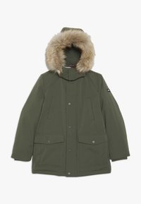 Parka vert olive avec capuche bordée de fourrure, multiples poches avant et fermetures à pression. Texture lisse, éléments de design fonctionnels.