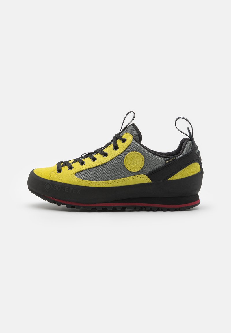 GORE-TEX čevlji s rumeno in sivo zgornjim delom, črnimi poudarki, strukturiranim gumijastim podplatom in sistemom vezalke z zankami za poteg.