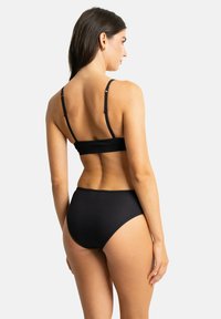 Bikini noir à côtes avec un bas taille haute et un bralette à double bande. Présente des bords sans couture et une texture douce.