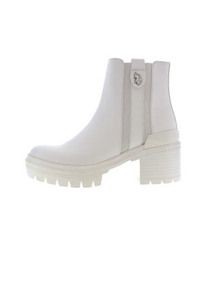 Valkoiset nilkkurit, joissa on sileä nahka, paksu korko, joustavat sivupaneelit ja teksturoitu kumipohja, jossa on karkeat urat.