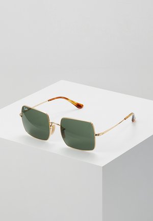 Occhiali da sole con montatura in metallo dorato e lenti verde scuro. Lenti quadrate, punte color marrone e aste sottili con dettagli del logo.