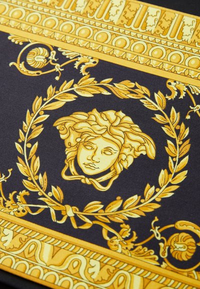 Must mustrõngid must materjal, millel on kuldsed barokk-mustrid, sealhulgas keskmine ornamentaalne nägu, mida ümbritsevad loorberilehed ja keerulised detailid äärtes.