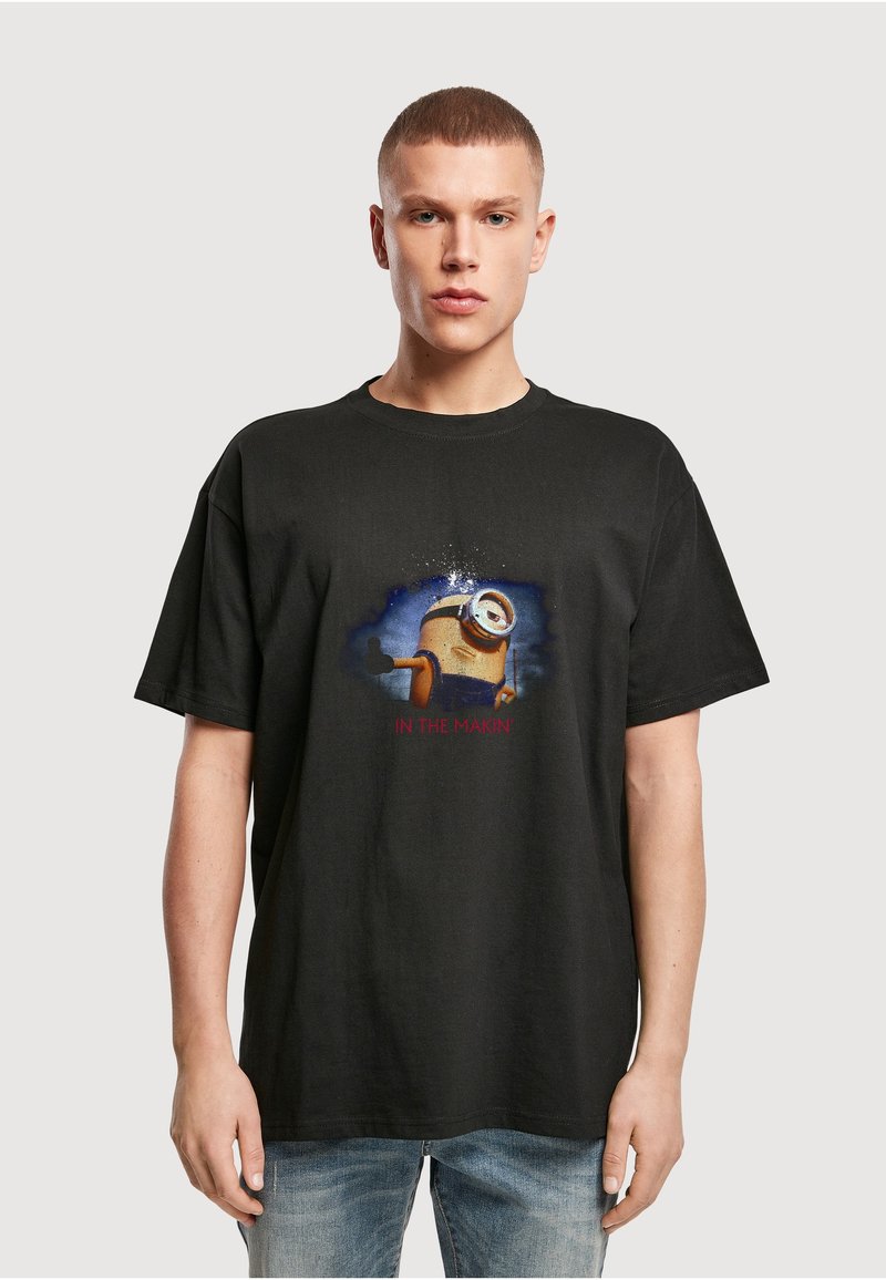 T-shirt en coton noir avec un graphique imprimé de Minion et le texte "IN THE MAKIN'" en dessous, manches courtes et coupe décontractée.