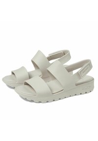 Sandali bianchi leggeri con due ampie cinture, punta aperta e supporto per la caviglia. Materiale testurizzato con una suola spessa progettata per il comfort.