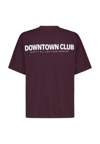 Weinrotes, übergroßes T-Shirt mit kurzen Ärmeln. Auf der Rückseite steht in weißem Text: "DOWNTOWN CLUB RISK IT ALL FOR YOUR PASSION."