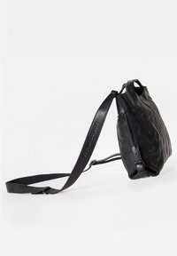 Sac en cuir noir avec une texture douce, un design unique plissé, des poignées courtes et une longue sangle réglable pour différentes options de transport.