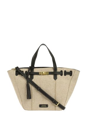 Sac à main rectangulaire en tissu beige avec poignées en cuir noir, bandoulière réglable, fermoir doré et détail en pompon.