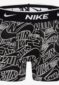 Sorte boxer briefs med et gentaget hvidt Nike-logo mønster, elastisk taljebånd og blødt stof med en glat tekstur.