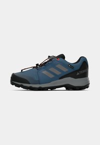 Plava trailska cipela s teksturiranim sintetičkim gornjištem, crnim gumenenim potplatom, sivim detaljima, GORE-TEX logom sa strane i narančastim vezicama za čvrsto prianjanje.