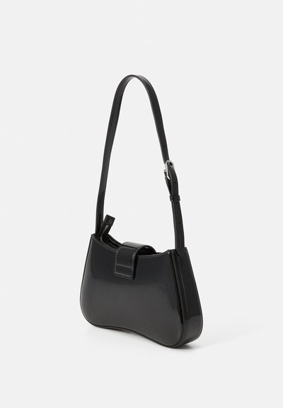 Bolso de mano en charol negro con forma curva, correa ajustable y cierre de cremallera. Presenta una textura suave y brillante.