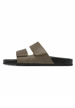 Sandales en cuir marron avec deux straps en velcro ajustables, une semelle intérieure anatomique et une semelle en caoutchouc noir, présentant un design minimaliste.