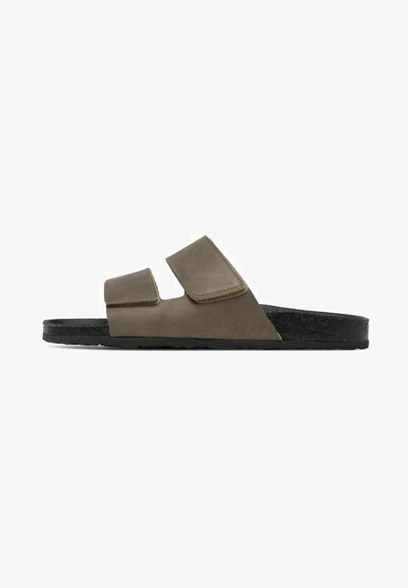 Sandales en cuir marron avec deux straps en velcro ajustables, une semelle intérieure anatomique et une semelle en caoutchouc noir, présentant un design minimaliste.