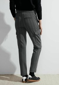 Pantaloni a motivo houndstooth grigio e nero con tasche laterali, caratterizzati da una linea dritta e un leggero elastico per comfort.