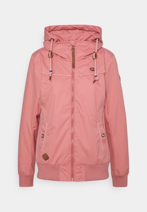 Veste à capuche rose clair en matériau résistant à l'eau avec une fermeture éclair frontale, capuche à cordon de serrage et poches latérales. Accents marron et détails de branding.