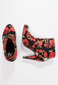 Schwarze Stiefeletten mit roter floraler Stickerei, spitzer Zehenform, hohem Absatz, seitlichem Reißverschluss, strukturiertem Stoff und dekorativer Naht.