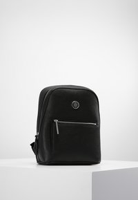 Czarny plecak z sztucznej skóry o zaokrąglonym kształcie, z przednią kieszenią na suwak i małym logo na przednim panelu. Gładka faktura, minimalistyczny styl.